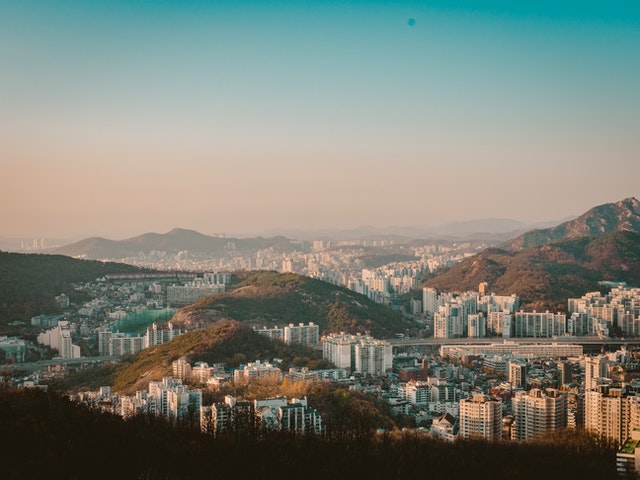 A foggy morning view of Seoul city contrasted with the foresty hills the city is built around