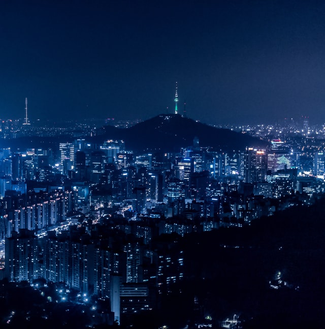 Aerial night view of the city covered in vibrant lights co