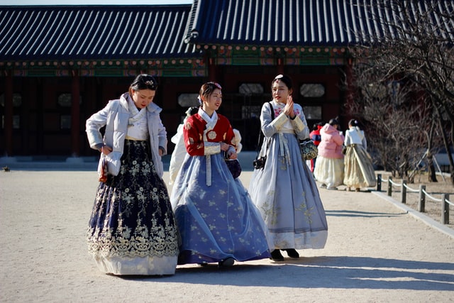 A photo of several women wearing traditional dresses in a shrine or palace.